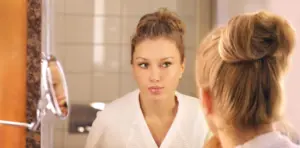 Confident woman looking in mirror, positive body image