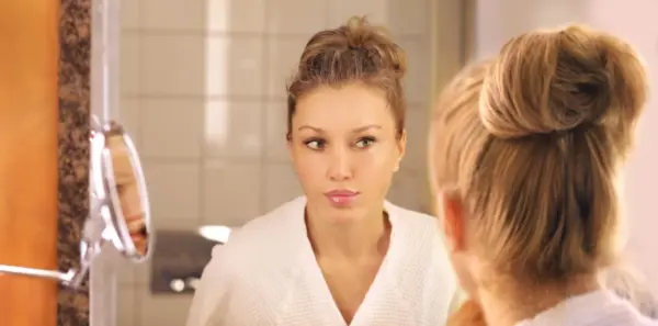 Confident woman looking in mirror, positive body image
