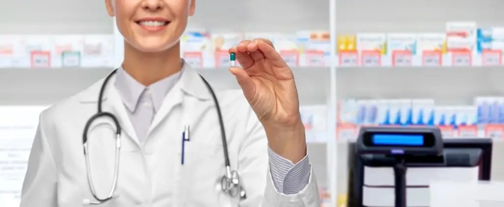 Woman smiling while holding supplement capsule