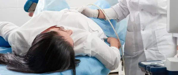 Cropped view pregnant woman undergoing ultrasound test gynecologist office