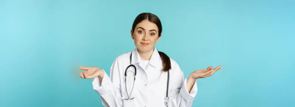 Portrait doctor woman intern shrugging shoulders smiling saying sorry dont know being clueles